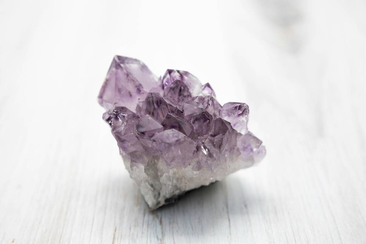 Amethyst and clear quartz healing crystals for skin conditions arranged on linen cloth