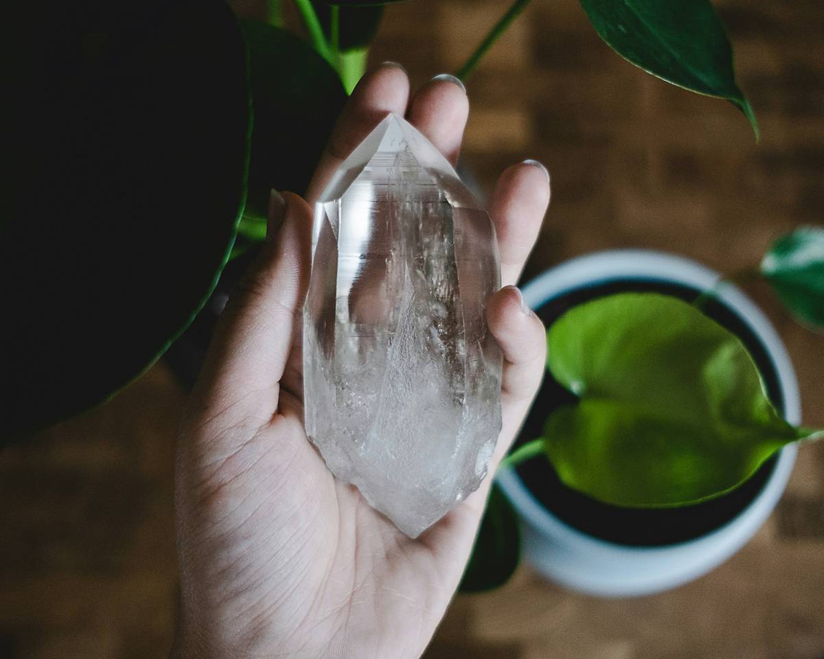 Woman applying rose quartz healing crystals for skin conditions on her cheek