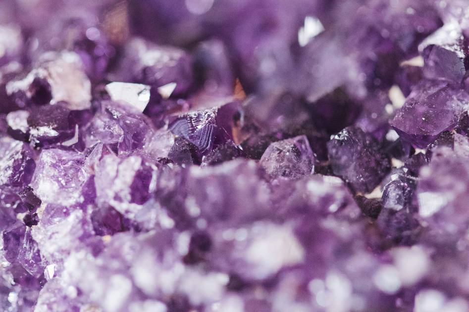 Organic crystals arranged on soft linen with rose quartz and amethyst